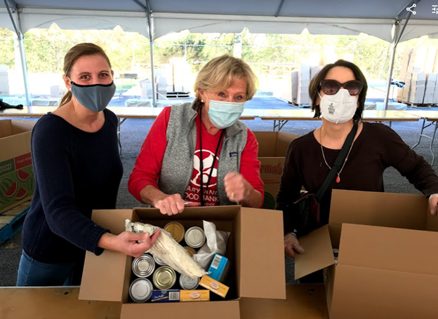 Melissa DeLong, Nancy Smith, and Havaca Ganguly packing Thanksgiving meals at the Maryland Food Bank.