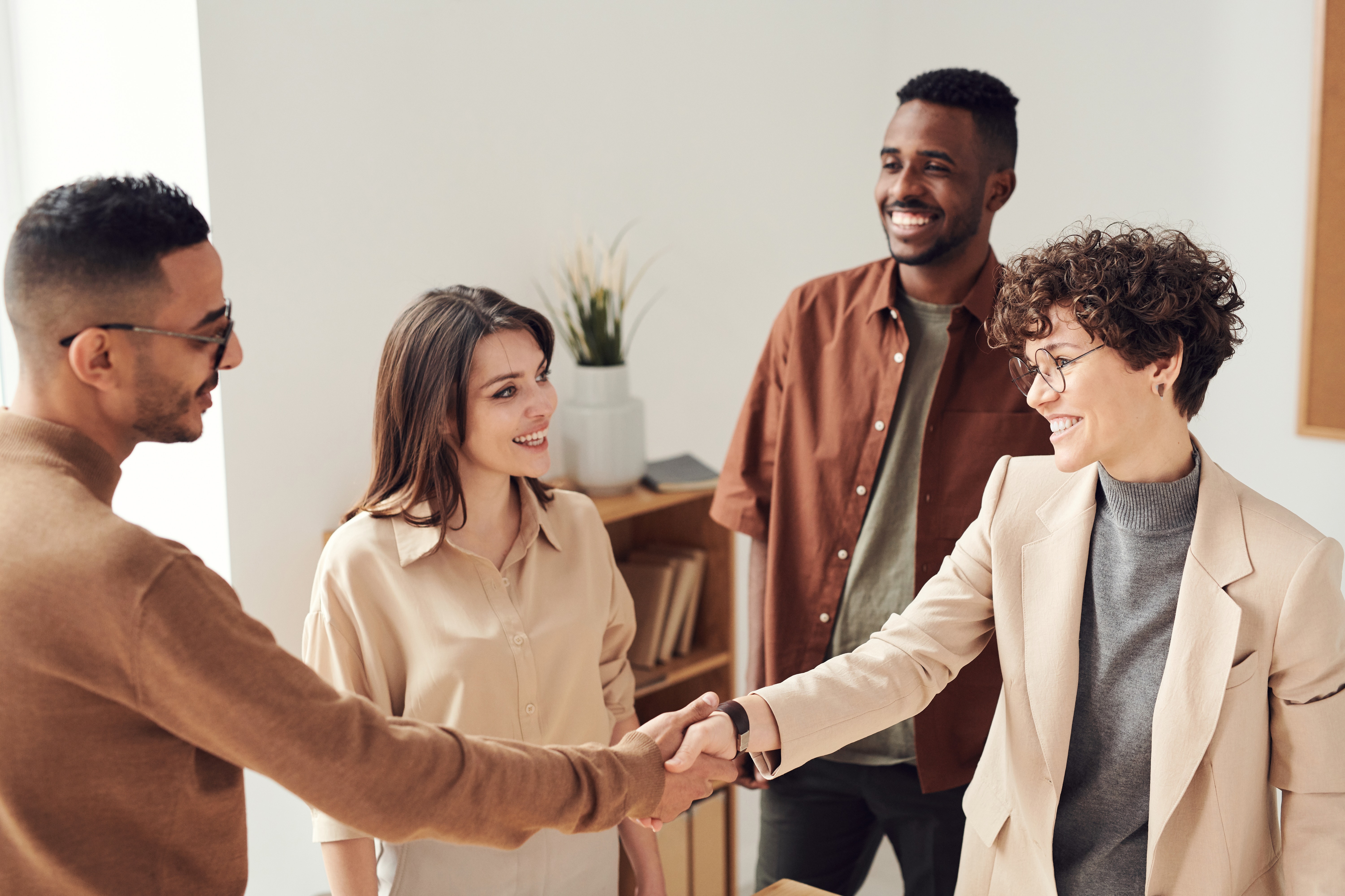 Small group of men and women in an office setting shaking hands