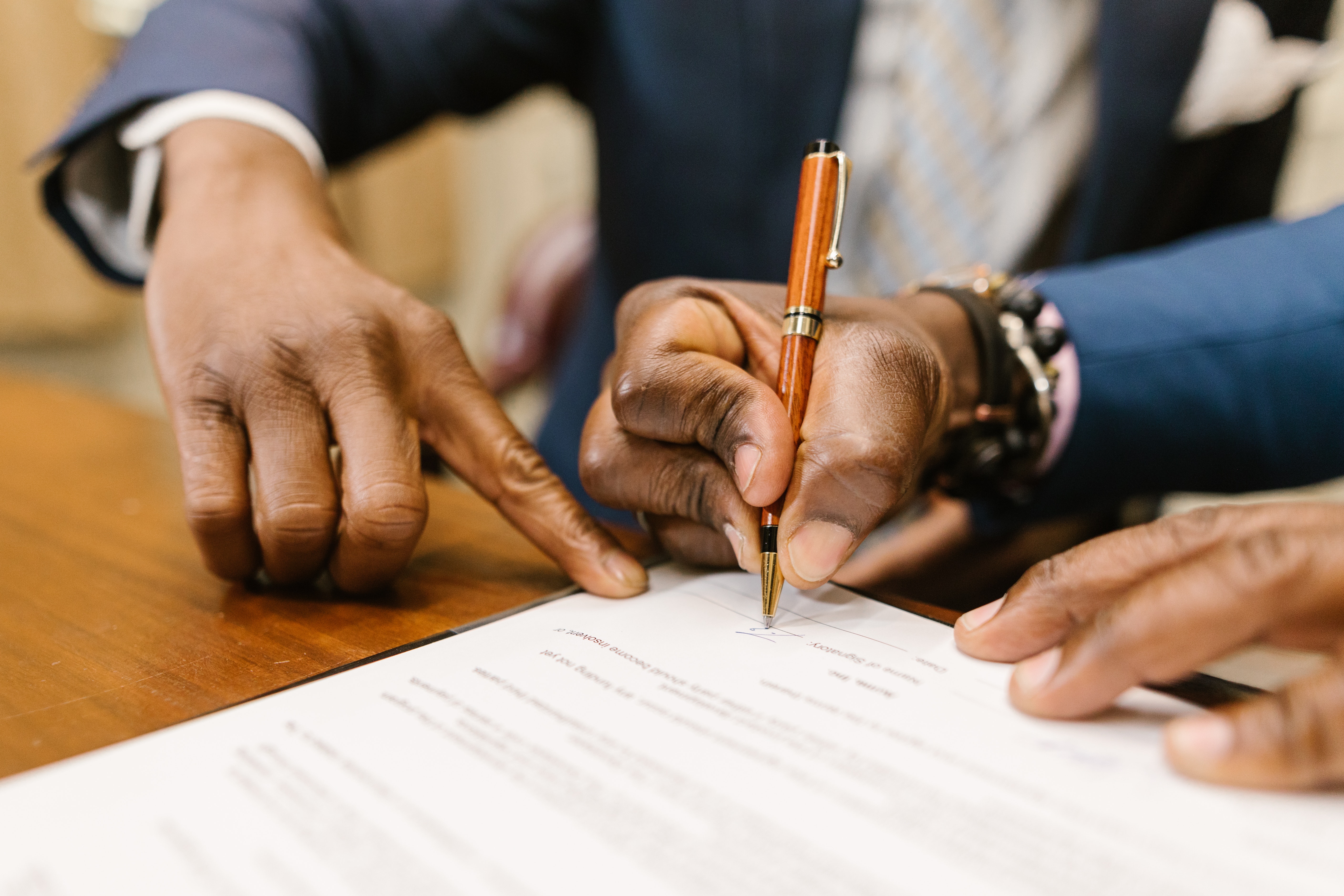 Two hands reviewing and signing a documnet